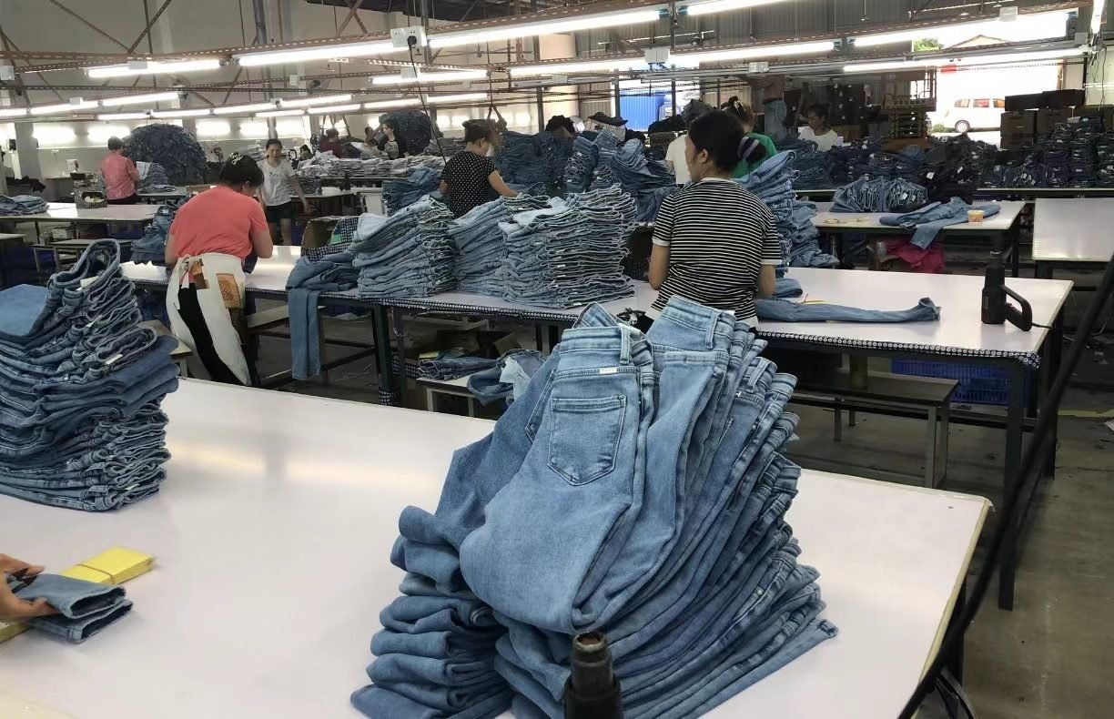 Finished denim garments stacked for checking at a partner production unit